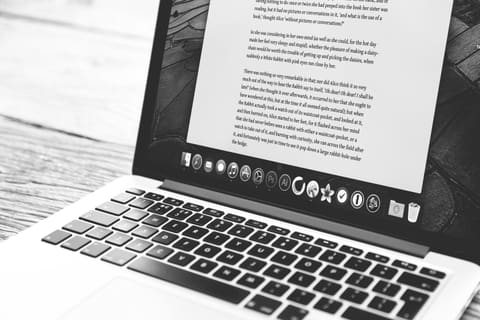 Laptop on a desk displaying a long page of article text
