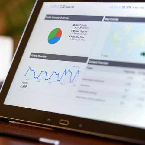 Tablet showing a website analytics report with traffic sources and visitor trends
